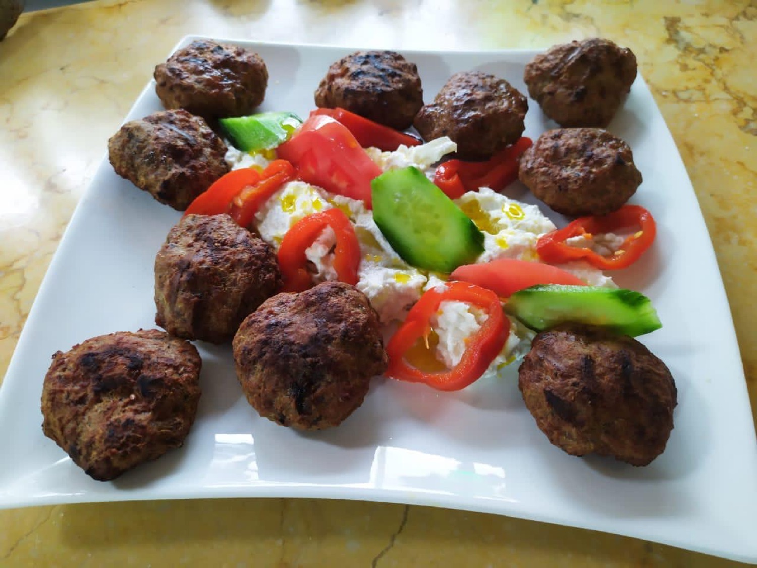 Grilled meatballs with a fresh feta and pepper salad