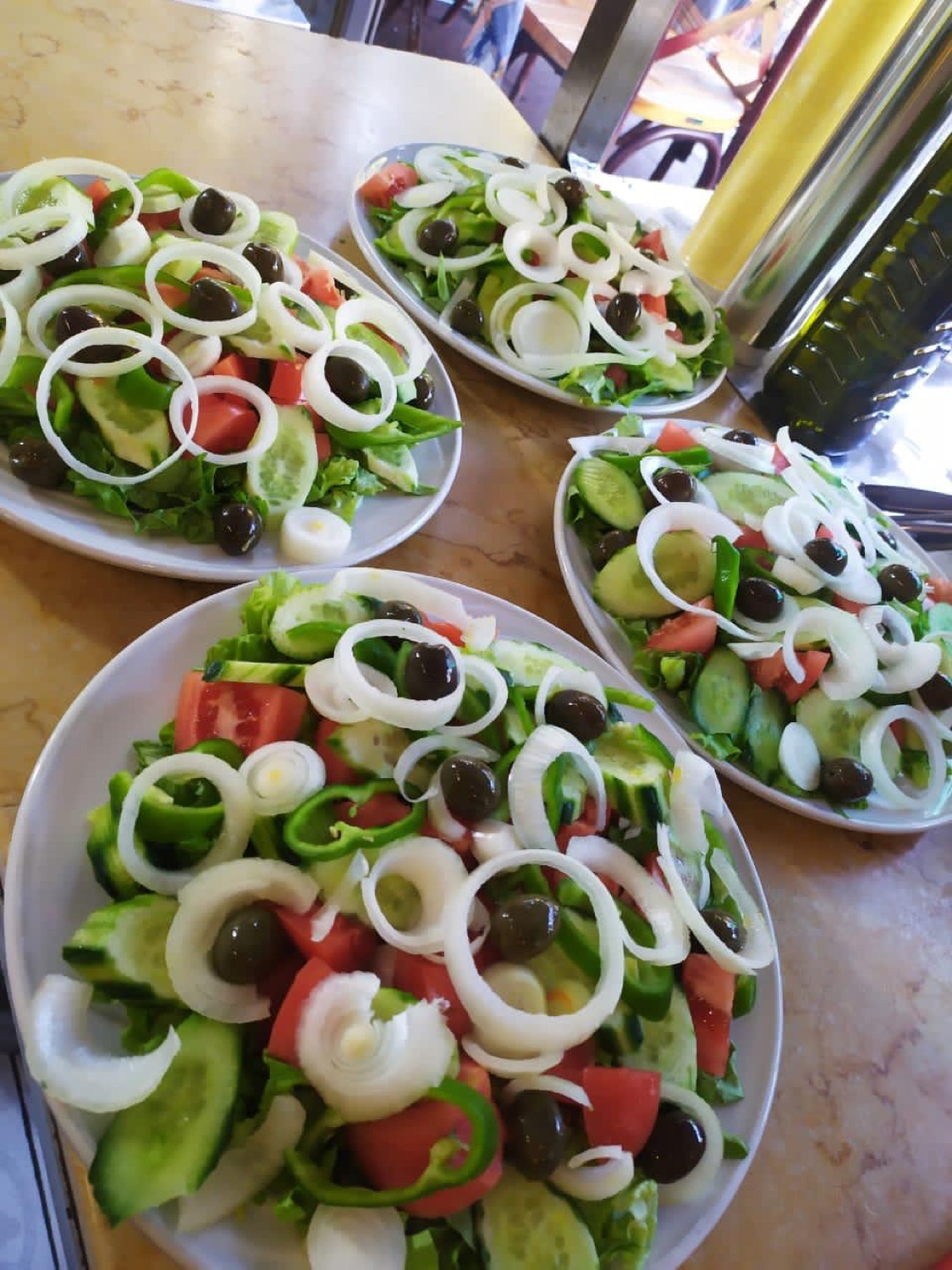 Four fresh village salads with onion, tomato and olives